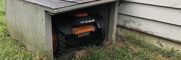 Mo, the robotic lawnmower, in his doghouse